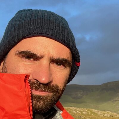 Pedro Vidigal in an orange jacket on the cliffs at Neist Point, Skye